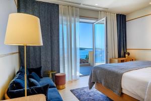 a hotel room with a bed and a large window at Luxury Villa Hvar Deluxe Palace 1 with heated pool, gym and sauna in Hvar