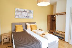 a bedroom with a large bed with yellow pillows at Gästezimmer Victoria in Linsberg