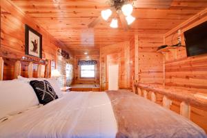 um quarto com uma cama num chalé de madeira em Sleepy Willow Cabin em Sevierville