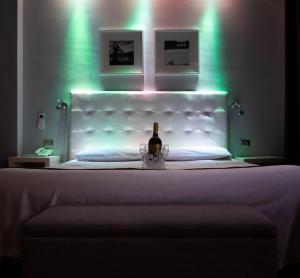a bottle of wine sitting on a bed with lights at Hotel Orcagna in Florence
