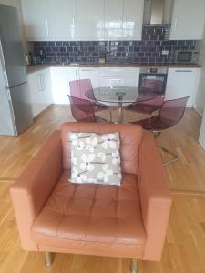 a living room with a brown couch and a glass table at Amazing 2 Bed 2 Bath Apartment City Centre Free Secure Parking in Cardiff