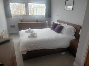 una camera da letto con un grande letto con asciugamani di Amazing 2 Bed 2 Bath Apartment City Centre Free Secure Parking a Cardiff