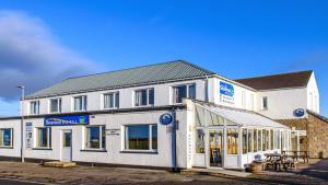 un grande edificio bianco con un negozio di fronte di Seaview John O Groats Hotel a John O Groats