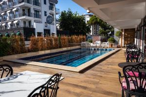 a swimming pool with tables and chairs next to a building at Espina Hotel in Antalya