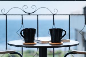 two black coffee cups sitting on a table at Espina Hotel in Antalya