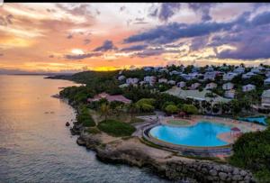 une vue aérienne d'un complexe hôtelier avec piscine dans l'établissement L'oiseau du Paradis vue mer Studio a Saint Francois a 100 m de la plage, à Saint-François