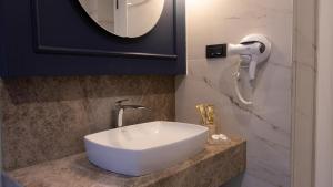 a bathroom with a white sink and a mirror at Espina Hotel in Antalya