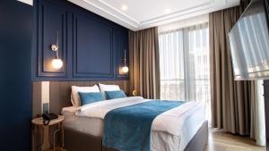 a bedroom with a large bed with blue walls at Espina Hotel in Antalya