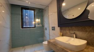 a bathroom with a sink and a toilet and a mirror at Espina Hotel in Antalya