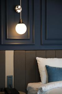 a light hanging over a bed with a blue wall at Espina Hotel in Antalya