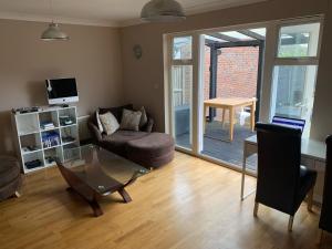 a living room with a couch and a table at Entire Family Entertainment Holiday Home - 3 x Floors - Free Parking - Games Room - Private Garden - Workspace and Wifi 112mb - Self Check-in in Ashford