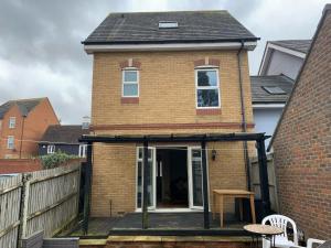 a extension to a house with a deck at Entire Family Entertainment Holiday Home - 3 x Floors - Free Parking - Games Room - Private Garden - Workspace and Wifi 112mb - Self Check-in in Ashford