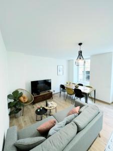 a living room with a couch and a dining room at Le convivial, appartement Centre ville Mulhouse in Mulhouse