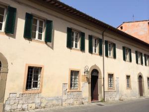 ein altes Gebäude mit grünen Rollläden drauf in der Unterkunft San Tommaso in Pisa