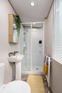 a bathroom with a shower and a sink at Linwater Holiday Park in Newbridge