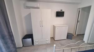 a room with a white cabinet and a television at The Simo's House Camere a Marzamemi in Marzamemi