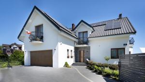 a white house with a gate and a driveway at Willa Arkadia w Pucku in Puck