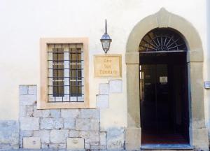 Un bâtiment avec une porte et un panneau qui dit café san francisco dans l'établissement San Tommaso, à Pise