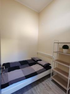 Dormitorio pequeño con cama y estante en AApartman Exclusive, en Pécs