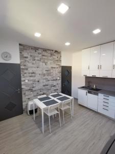 una cucina con tavolo bianco e muro di mattoni di AApartman Exclusive a Pécs