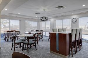 劳顿MySuites Lawton的一间有桌椅和钟的餐厅
