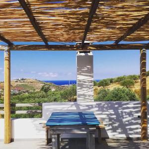 a picnic table on a patio with a view of the ocean at saveriako, paradise for relaxed free spirits in Agia Pelagia