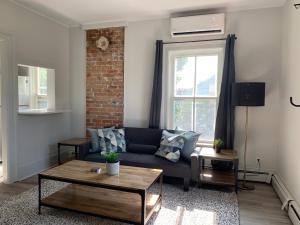 a living room with a blue couch and a brick wall at County Cove - Consecon Suite in Wellington