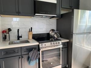 a kitchen with a stove and a sink and a refrigerator at County Cove - Consecon Suite in Wellington