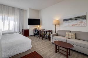 劳顿MySuites Lawton的一间配有床、沙发和桌子的酒店房间 更多37张照片