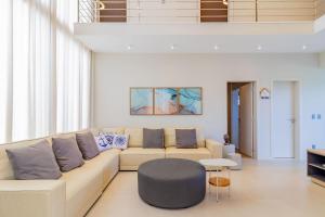 uma sala de estar com um sofá e uma mesa em SA05 Excelente Casa 5 Suítes - Condomínio Reserva de Sauípe na Costa do Sauípe