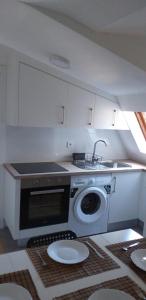 a kitchen with a sink and a washing machine at APARTAMeNTOS DON MANUEL A in Cee
