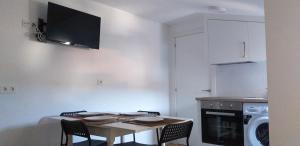 a kitchen with a table with chairs and a microwave at APARTAMeNTOS DON MANUEL A in Cee +8 photos
