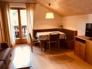 een woonkamer met een tafel en een televisie bij Matailerhof in Tirolo