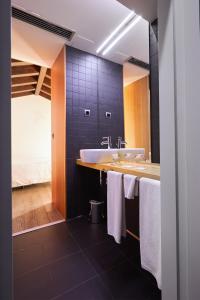 a bathroom with a sink and a large mirror at María Pacheco Hotel Boutique in Avila