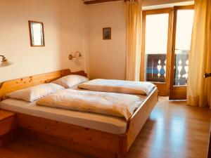 a bedroom with two beds and a large window at Matailerhof in Tirolo