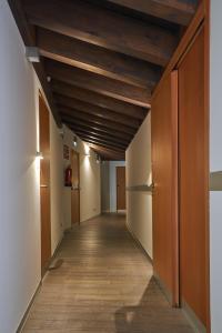 un pasillo en un edificio de oficinas con techos de madera en María Pacheco Hotel Boutique, en Ávila