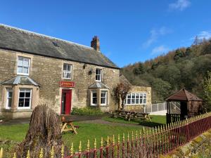 an old stone building with a red door at The Elks Head Inn in Whitfield +18 photos