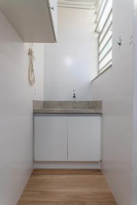 une cuisine aux murs blancs avec un évier et une fenêtre dans l'établissement Moderno em Copacabana - Ideal para casais - SC305LT Z4, à Rio de Janeiro