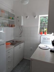 a white kitchen with a sink and a window at Holiday Home Dragan - 50m from sea in Splitska
