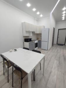cocina con mesa blanca y sillas en una habitación en Апартаменты Жасмин, en Karagandá