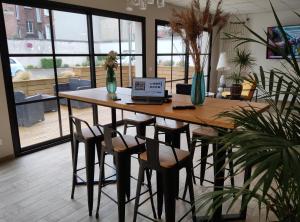 una mesa de madera con sillas y un ordenador portátil. en Villa Raphaëlle #3 Centre ville avec parking, en Le Havre 23 fotos más