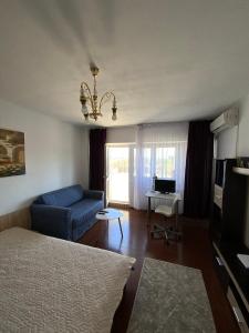 een woonkamer met een blauwe bank en een televisie bij Le Garçon de Adi-Cosy,Quiet,Spatious Studio in Boekarest
