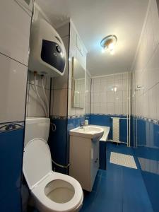 een blauwe badkamer met een toilet en een wastafel bij Le Garçon de Adi-Cosy,Quiet,Spatious Studio in Boekarest