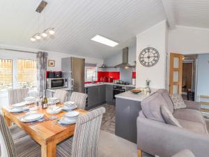 a kitchen and living room with a wooden table and chairs at Limefitt Lodge in Windermere