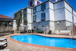 a hotel with a swimming pool in front of a building at Sleep Inn & Suites Ocala - Belleview in Marion Oaks