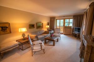 a living room with a couch and a tv at Apartment Chalet Rubihorn mit Berg-Blick in Bolsterlang