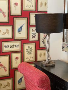 a red chair sitting next to a table with a lamp at Park Farm Hotel in Norwich