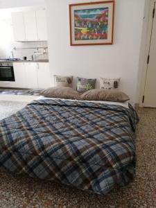 um quarto com uma cama com um cobertor xadrez em CASA MINU' - Affitti Brevi Italia em Bari