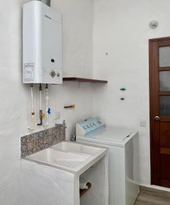 une cuisine blanche avec un évier et une machine à laver dans l'établissement Apartamento Rincón de los Olivos, à Villa de Leyva