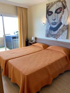 - une chambre avec 2 lits et un tableau mural dans l'établissement Apartment Stella Maris, à Fuengirola
